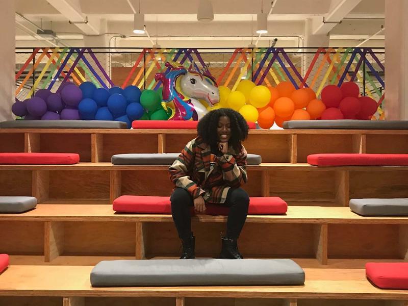 A Black woman sitting alone on some empty bleachers